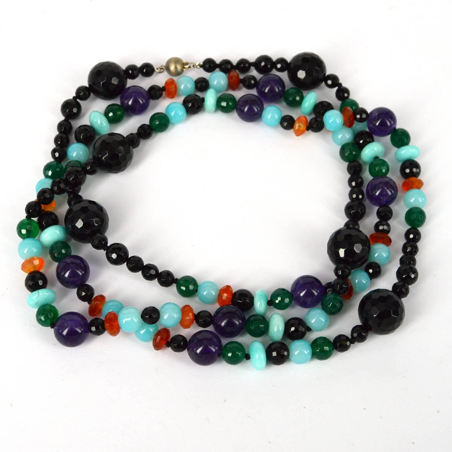 Barcelona long knotted necklace made from 6, 10 and 16mm faceted Onyx, 8mm Faceted Green Onyx, 8x5mm faceted Carnelian, 12mm polished Amethyst, 10x5mm Polished Peruvian Amazonite and 8mm aqua glass beads with a 8mm brushed Sterling silver