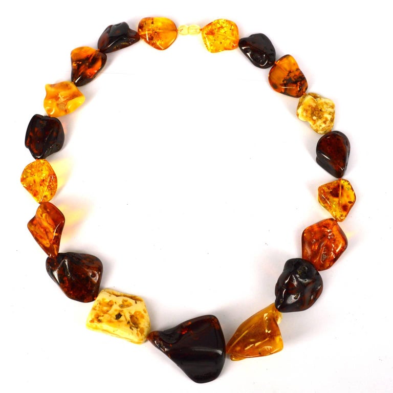 Free form Butter, Honey, Cognac, Cherry and Lemon Nuggets of Baltic Amber ranging from 25x22mm up to 40x45mm with a twist opening resin clasp.

Baltic amber is fossilized tree sap and is over 50 millions years old.