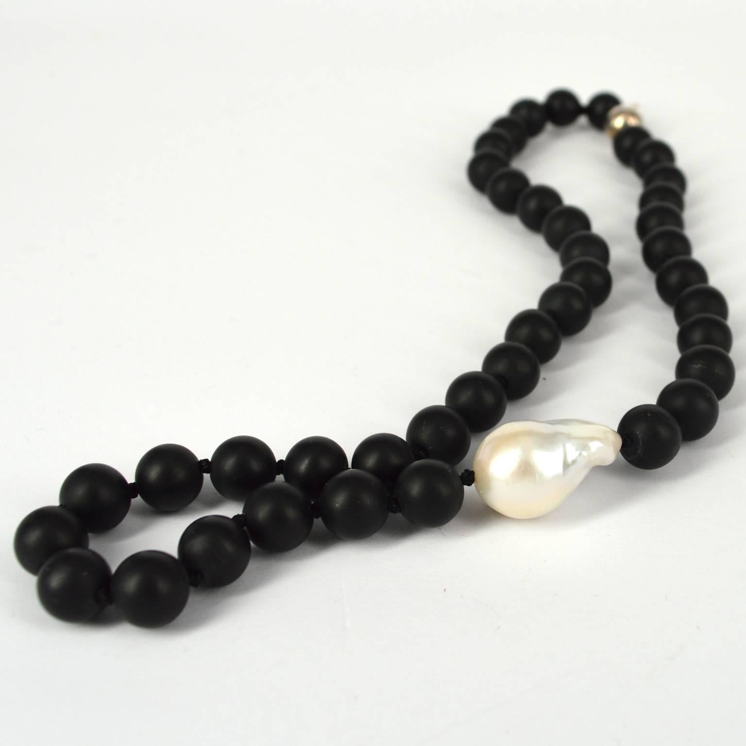 Classic necklace with a  large Baroque Fresh Water Pearl positioned off center  knotted with 10mm Matt Onyx beads and a 10mm Sterling Silver Clasp. 
this design can be supplied in polished or Faceted onyx upon request. 
Finished necklace measures