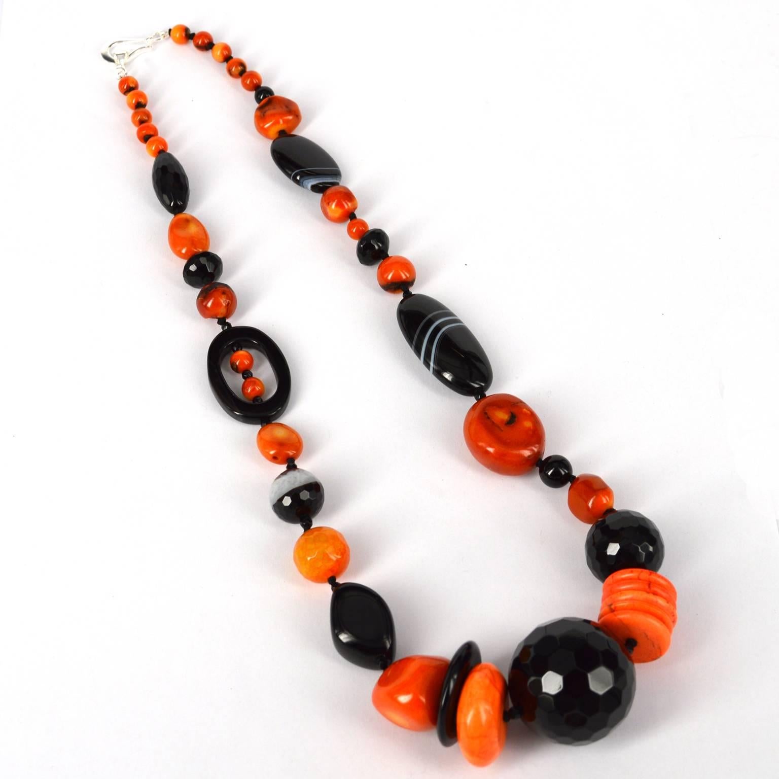 A mix of different shapes makes up this necklace with dyed bamboo coral nuggets, dyed howlite disks, faceted onyx rounds and black agate shapes.
The large faceted onyx round measures at 29mm. Hand knotted on black thread.
Total length of necklace is