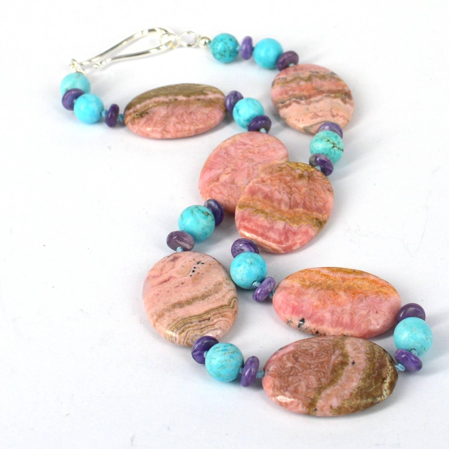 Rhodochrosite 35x25mm with 10mm Natural Hubei Turquoise and 8x3mm Charoite rondel beads, hand knotted on Aqua thread for strength and durability with a 55cm Sterling Silver Hook Clasp.
Finished Necklace measures 51cm
