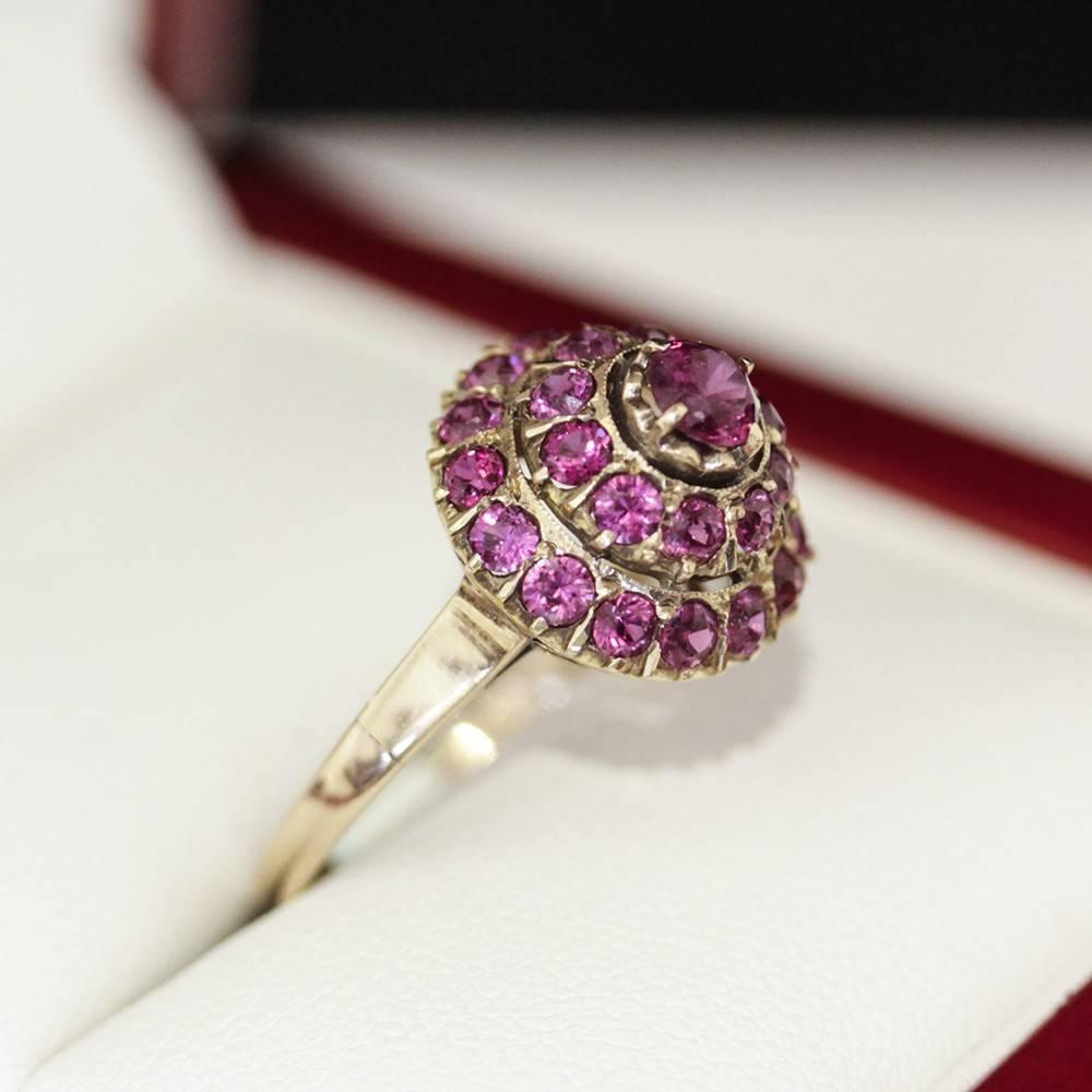 Recently restored Vintage Ruby dome ring with spectacular, nearly Fuchsia coloured Natural Rubies in a Rosey Gold setting, circa 1940s, wonderful Cocktail Dinner ring. 

A 14ct yellow gold ruby ring featuring a round ruby four claw set surrounded by