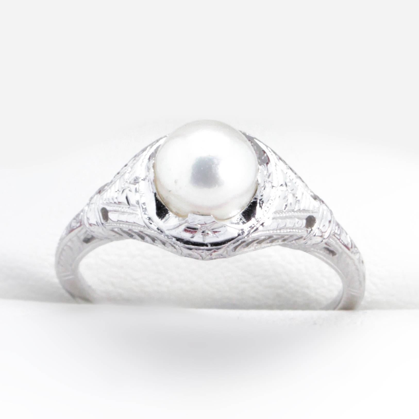 Antique Art Deco Pearl and Filigree Engagement or Cocktail Ring

An 18ct White Gold Art Deco antique filigree Pearl Ring featuring a cultured Pearl, four claw set in a 3.50 - 0.80mm wide half round tapered shank, stamped 18k. 

The ring is in a very