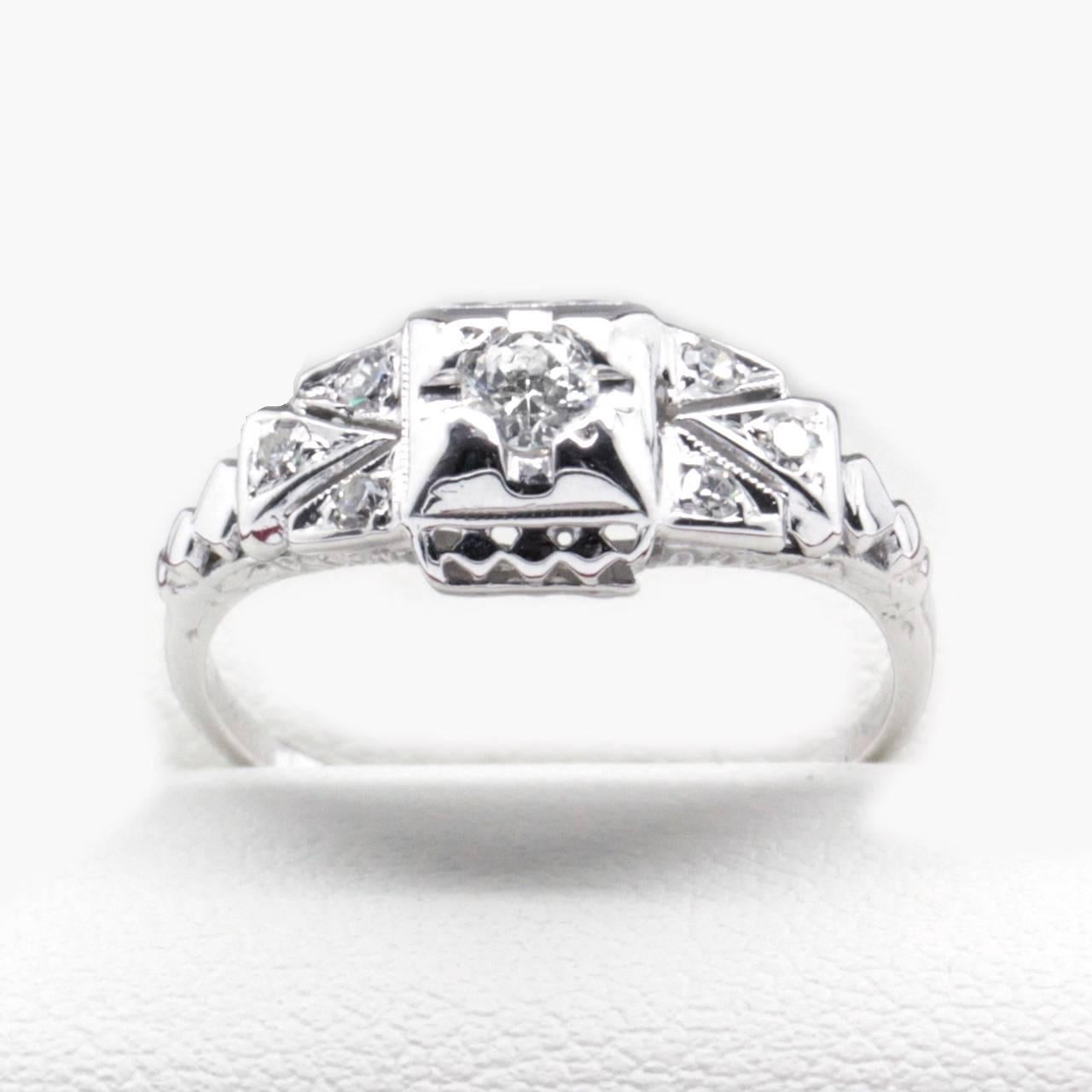Art Deco Diamond Ring in 14k White Gold featuring diamonds weighing a total of approximately 0.20 carat.

The white gold filigree shoulders feature three small, white and very sparkly Diamonds within the adjoining triangles on either side of a