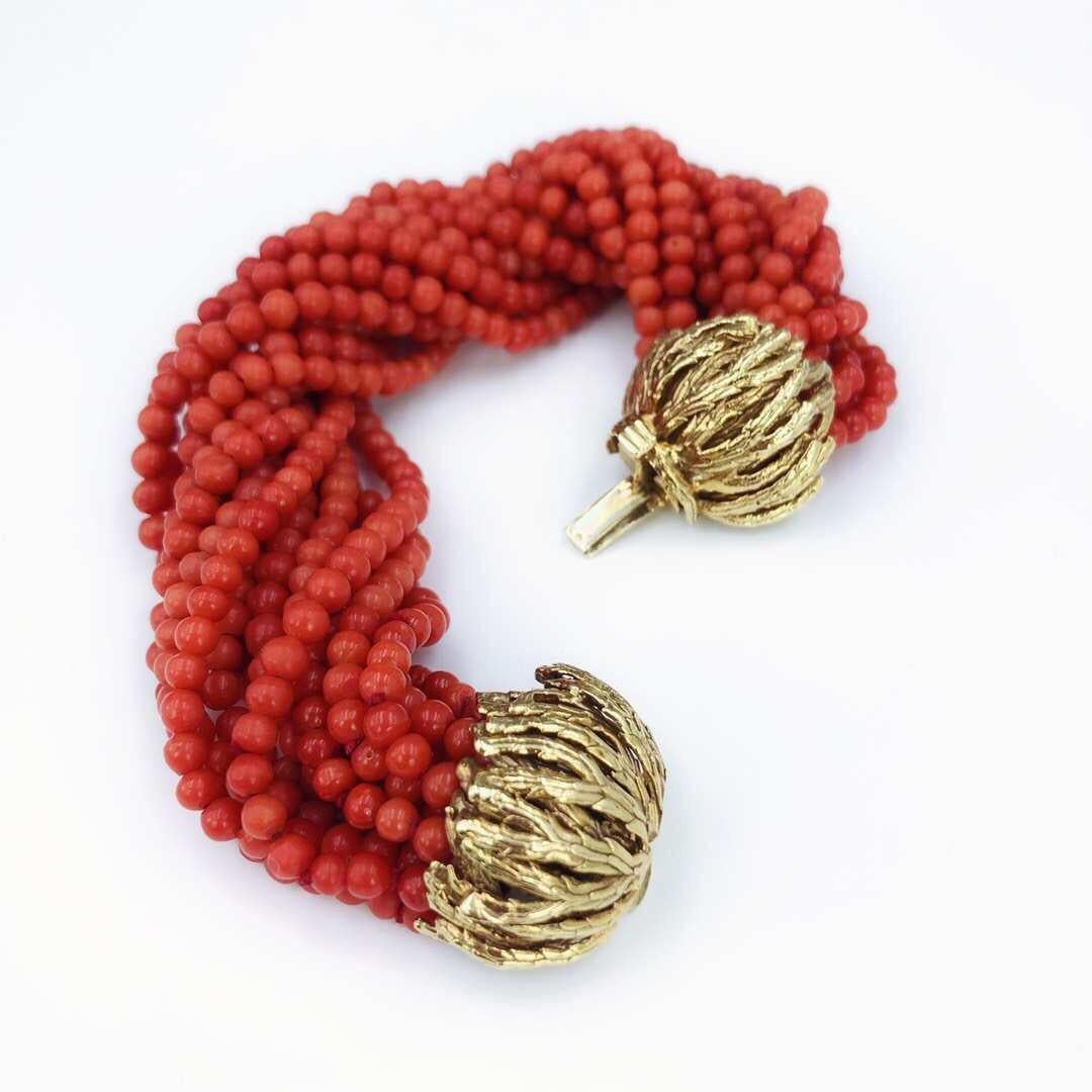 A 1970s coral multi-strand bracelet. The coral bead strands, gathered to textured, foliate terminal clasps. Length 19cms. Total weight 90.5gms. Coral untested.Coral beads measuring 3.9 to 3.7mms.
Stamped 14k.