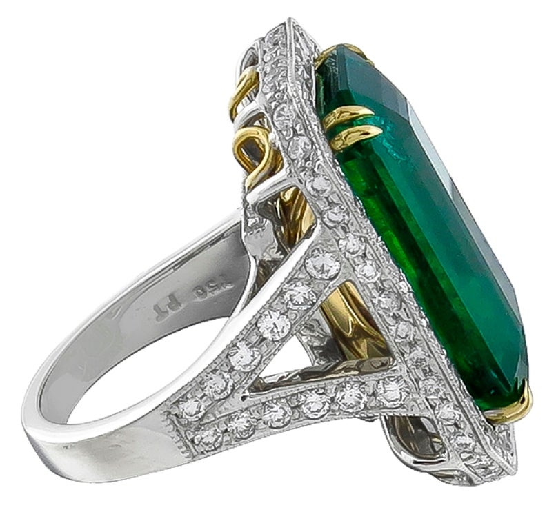Réalisée en platine et or jaune 14k, cette bague est centrée sur une émeraude de taille émeraude qui pèse 17,75ct. L'émeraude est accentuée par des diamants étincelants de taille ronde pesant environ 2,50ct. La bague est de taille 6 1/4, et peut
