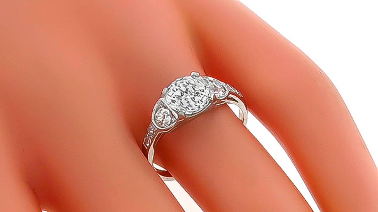 Hergestellt aus Platin, dieser Ring verfügt über eine funkelnde GIA-zertifizierte Jubiläum geschnitten Diamant, der 2,02ct wiegt. abgestuft J Farbe mit SI1 Klarheit. Der zentrale Diamant wird durch schillernde Diamanten im Altminenschliff mit einem