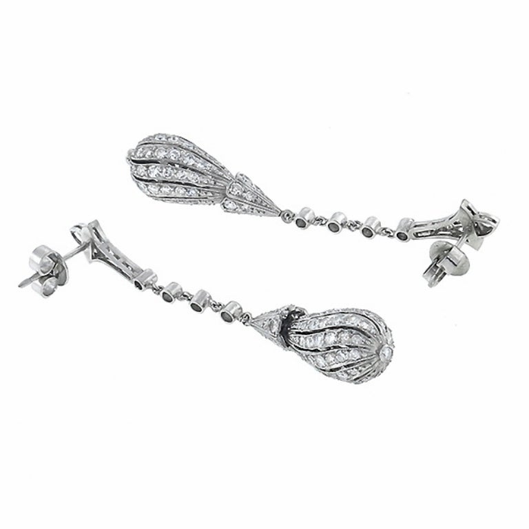 Made of platinum, these earrings feature sparkling old mine cut diamonds weighing approximately 5.00 carat. The color of the diamonds is G with VS clarity. The length of these earrings is 58mm and the width of the bottom part is 9.5mm.

Inventory