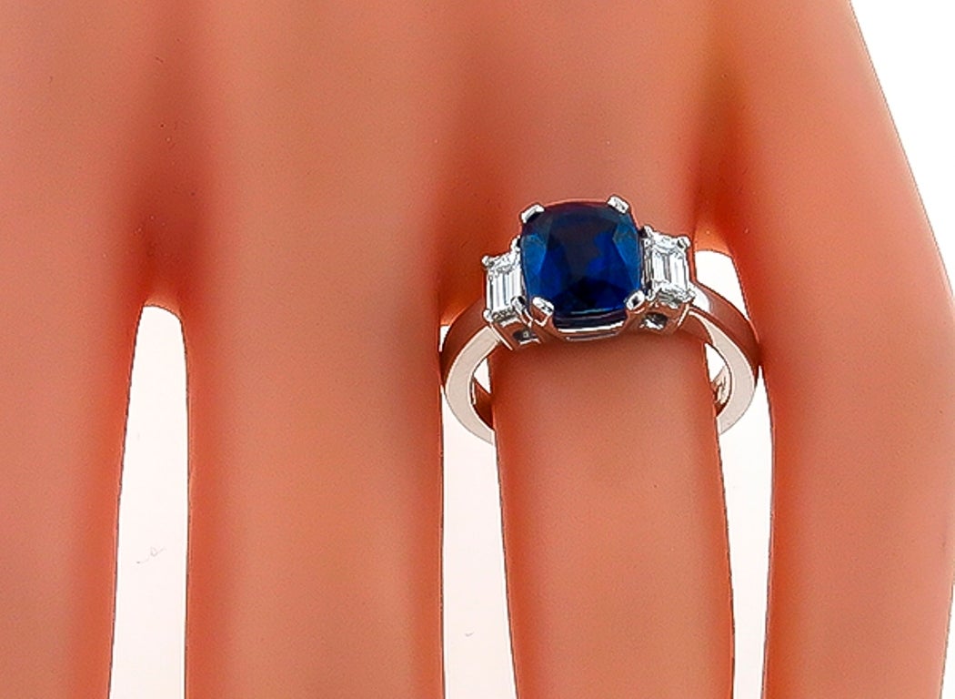 Made of Platinum, this ring centers a vivid blue GIA certified natural no heat cushion cut sapphire that weighs 3.44ct. The sapphire is flanked by sparkling emerald cut diamonds that weigh approximately 0.30ct. graded F color with VS1