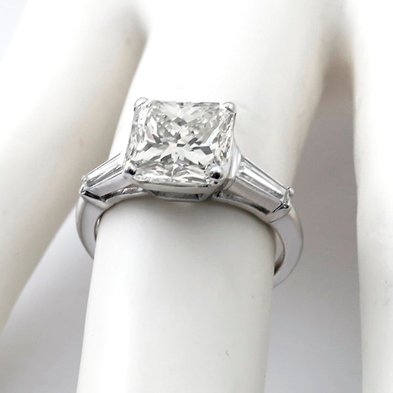 This beautiful platinum ring centers an EGL certified princess cut diamond that weighs 3.38ct. and is graded  I-J color with VS1 clarity. The center stone is flanked by baguette cut diamonds weighing approximately 0.40ct. The color of these diamonds