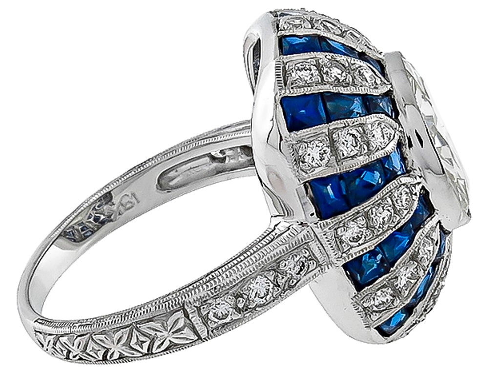 This ring is set with an EGL certified round cut diamond that weighs 3.13ct. and is graded J-K color with Si1 clarity. The center stone is accentuated by approximately 2.00ct French cut faceted sapphires and approximately 1.00ct of round cut