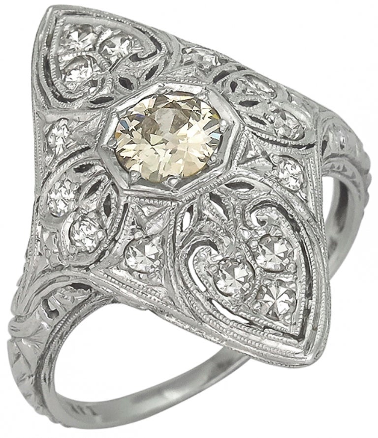 This gorgeous platinum ring from the Art Deco period, centers a beautiful old mine cut natural fancy yellow diamond that weighs approximately 0.45ct. The center stone is accentuated by dazzling round cut diamonds that weigh approximately 0.60ct. The