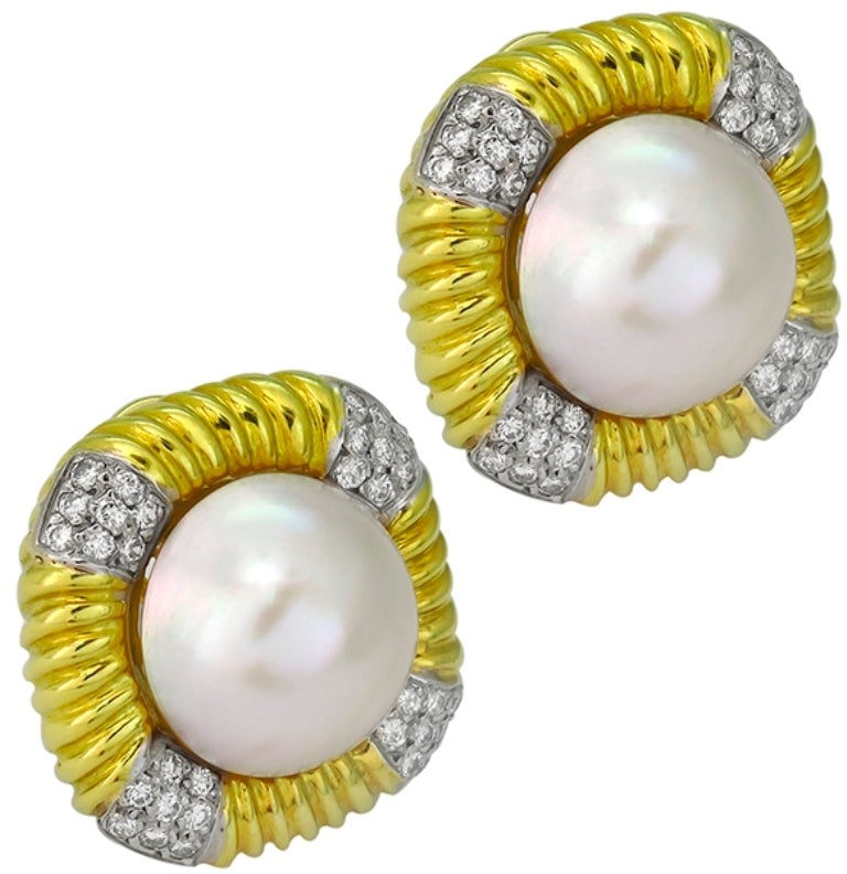 Made of 18k yellow and white gold, these earrings feature round mabe pearl that measure 15mm in diameter. The pearl is accentuated by sparkling round cut diamonds that weigh approximately 1.90ct. and are graded F-G color with VS clarity. The