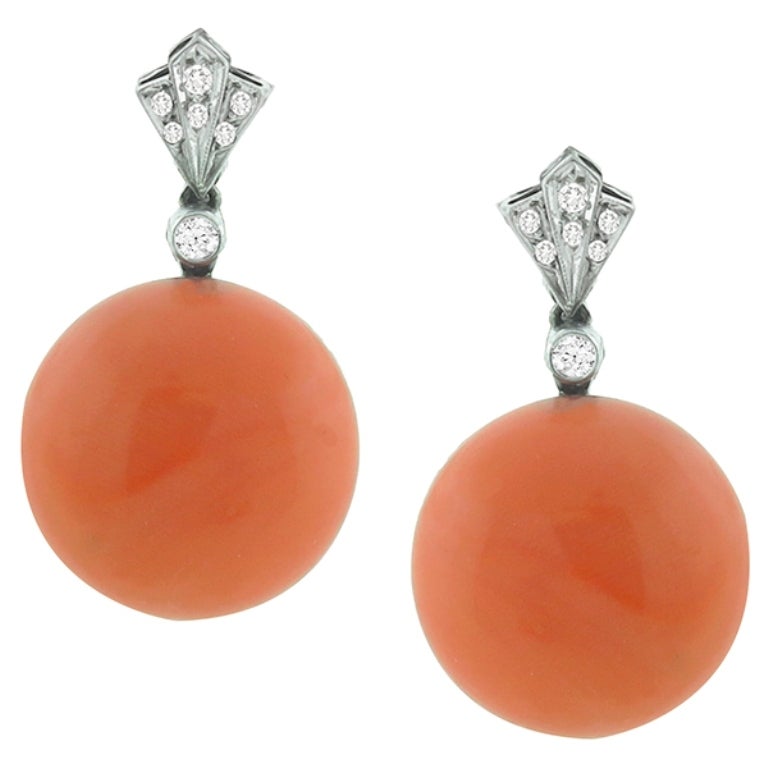 This beautiful pair of platinum earrings, are centered with a beautiful round cabochon coral. It is accentuated by sparkling round cut diamonds that weigh approximately 0.25ct. The color of the diamond is H with VS clarity. The earrings measures