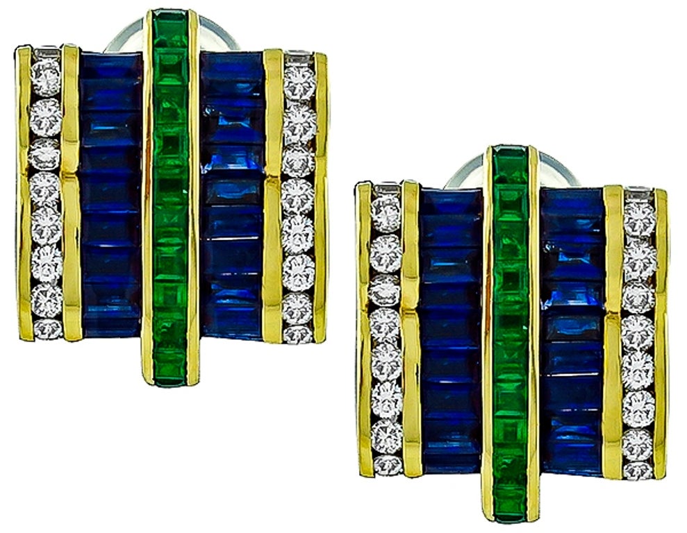 Made of 18K yellow gold, these earrings are set with sparkling round cut diamonds, square cut Colombian emerald, & baguette cut sapphires that weigh approximately 2.00ct, 1.20ct and 3.00ct respectively. The color of the diamonds is F with VS2