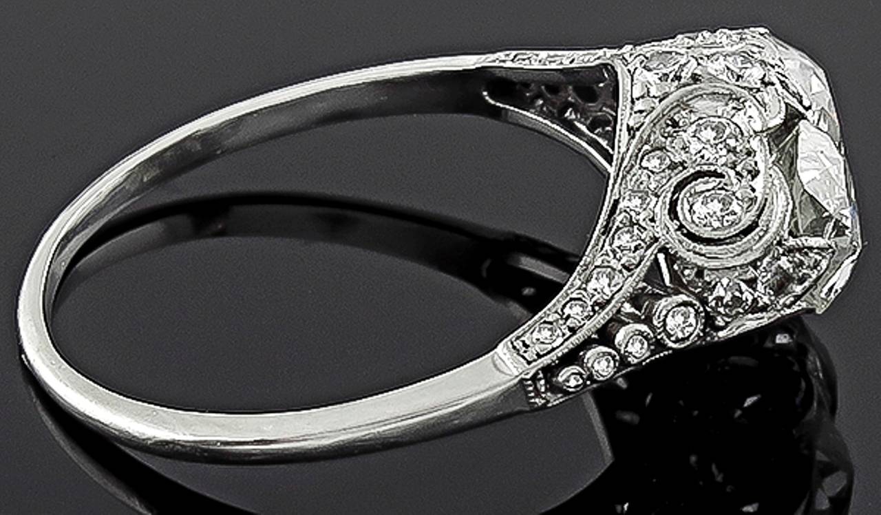 This stunning platinum ring from the Edwardian era, is centered by two sparkling cushion cut diamonds weighing approximately 1.90ct. The color of these diamonds is H-I with VS2 clarity. The center diamonds are accentuated by dazzling round cut