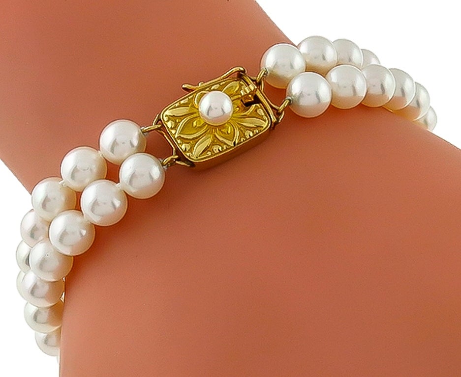 This amazing lustrous 2 strand Mikimoto cultured Pearl bracelet features an18k yellow gold traditional clasp with beautiful engraving and center pearl. These elegant gems of the ocean has a measurement of 12mm in width and 7 1/4 inches in length.