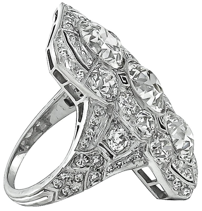 This gorgeous platinum ring features 3 sparkling old mine cut diamonds at the center that weigh approximately 4.00ct. The color of the diamonds is J with VS1 clarity. The center stones are accentuated by dazzling old mine and round cut diamonds that
