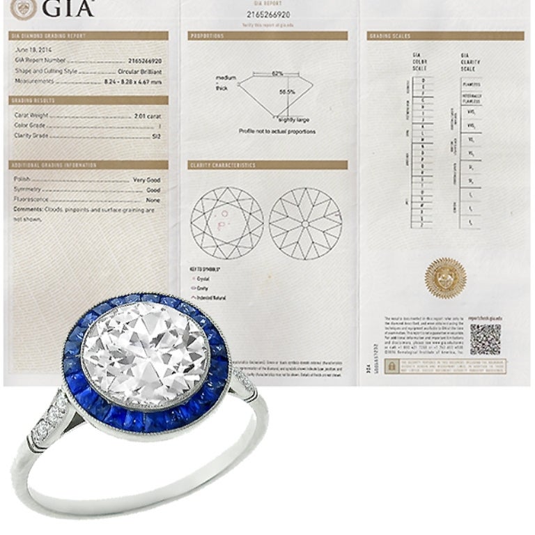 Made of platinum, this ring centers a sparkling GIA certified circular brilliant cut diamond that weighs 2.01ct. graded I color with SI2 clarity. The center stone is accentuated by calibre cut sapphires weighing approximately 0.40ct and round cut