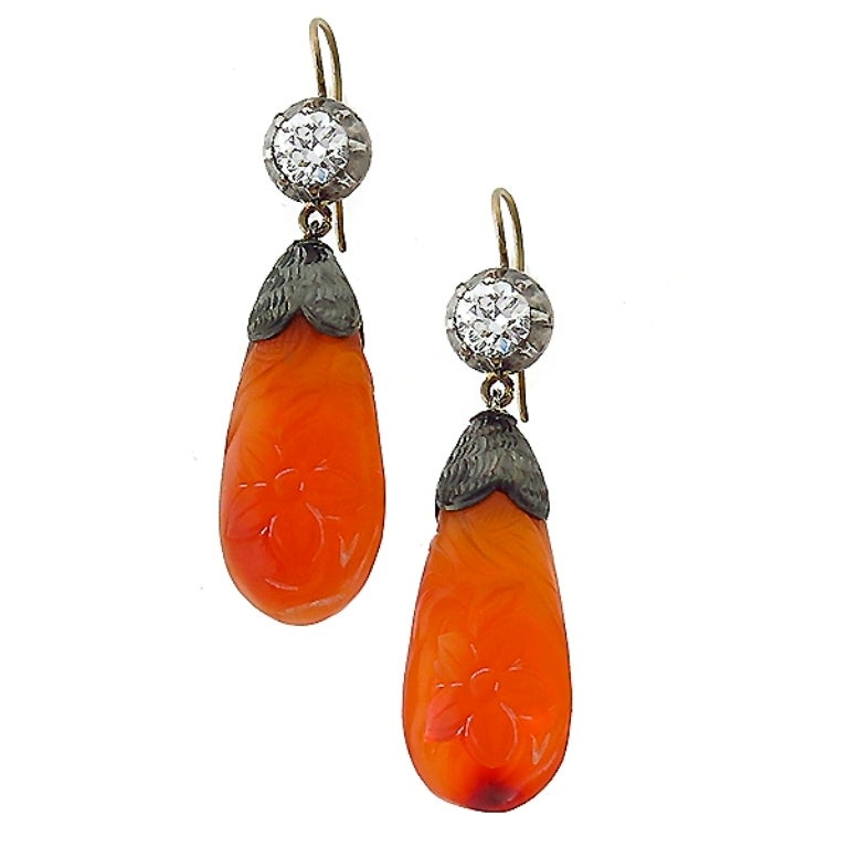 This is a gorgeous 14k yellow gold silver carnelian diamond earrings from the Victorian era. The earrings feature a carved carnelian with sparkling round cut old mine cut diamond that weighs 1.00ct. The color of the diamond is H with VS
