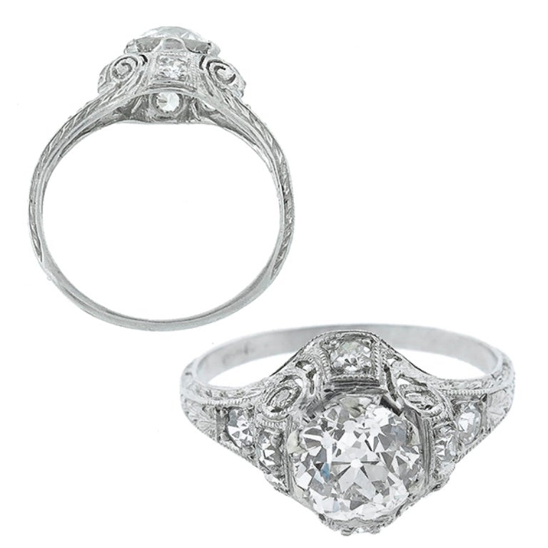 Handcrafted from the Edwardian era, this platinum ring centers a sparkling GIA certified old European cut diamond that weighs 1ct. and is graded G color with SI1 clarity. The top of the ring measures 11mm by 13mm. 
The ring is size 5 1/2, and can