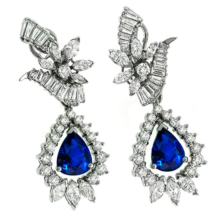 This stunning pair of 18k white gold earrings, is set with vivid blue pear shape sapphires weighing approximately 6.50 carat. The sapphires are accentuated by sparkling round and marquise cut diamonds weighing approximately 7.50ct and are graded F-G
