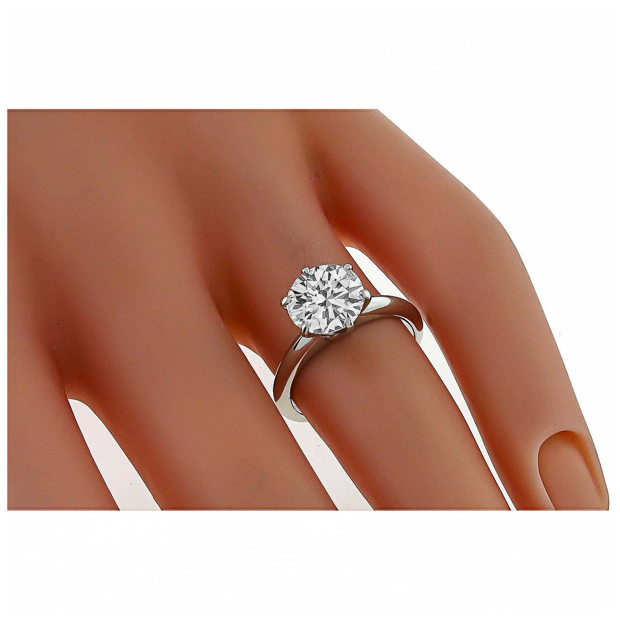 Glittering at the center of this Tiffany & Co platinum engagement ring is 2.14ct round brilliant cut diamond. The color of the diamond is I and the clarity is VVS2. The measurement of the top of the ring is 9mm in diameter. The ring is signed
