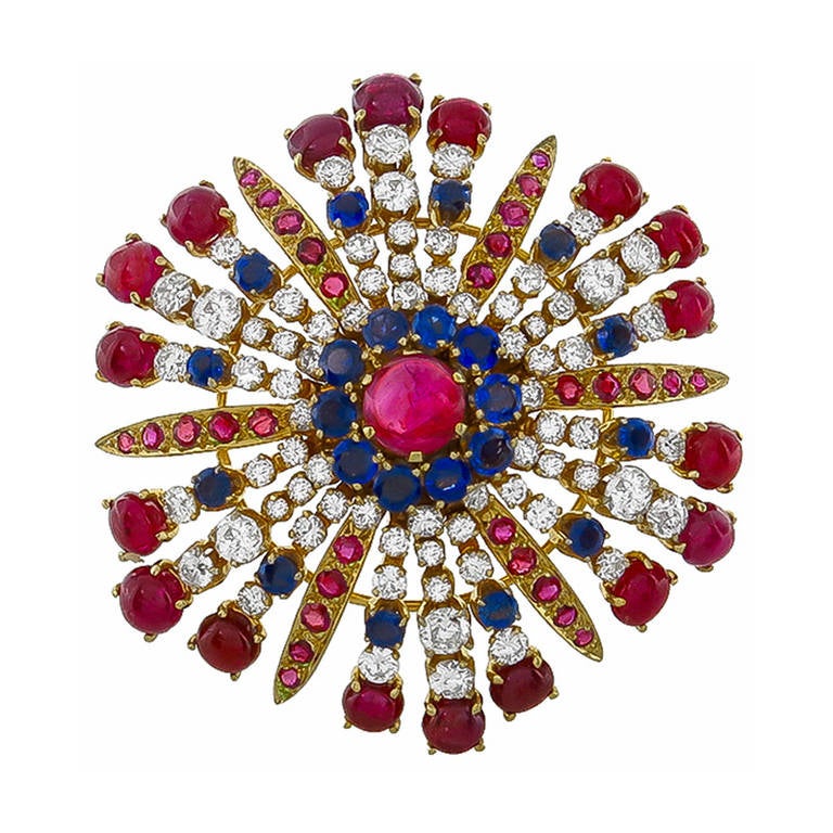 This is an elegant 1940s 18k yellow gold pin. The pin is set with lovely cabochon rubies, round cut sapphires and round and old mine cut diamonds that weigh approximately 16.50ct, 3.00ct and 6.00ct respectively. The color of the diamonds is G-H with