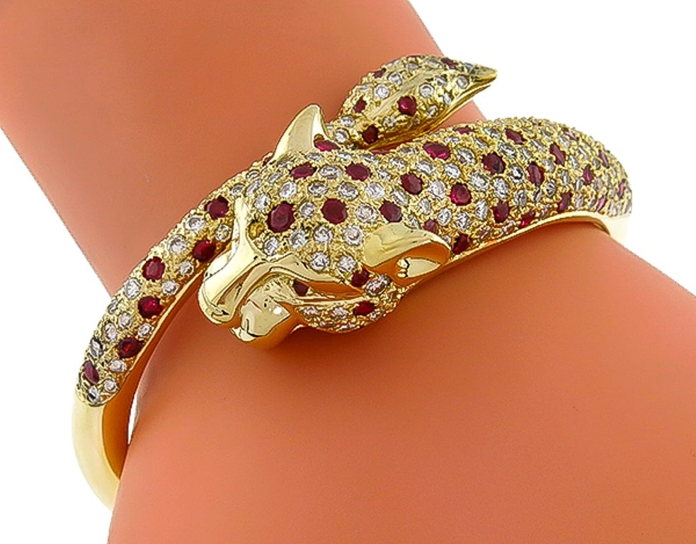 Made of 14k yellow gold, this bangle is set with sparkling round cut diamonds weighing approximately 7.00ct. and bright red rubies weighing approximately 3.50ct. The color of the diamond is G with VS clarity.
The bangle is stamped 585, and will fit