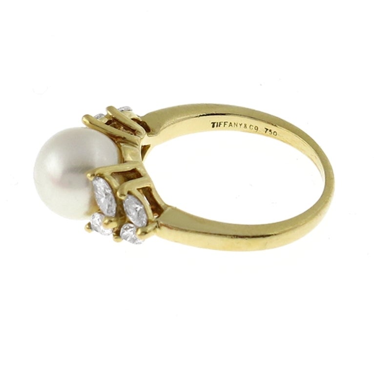 This lovely Tiffany & Co. 18k yellow gold ring centers a 8.5mm diameter pearl which is accentuated by sparkling marquise cut diamonds weighing approximately 1.25ct.

The size of the ring is 6 1/2, and it can be resized.

Inventory #29938KSS