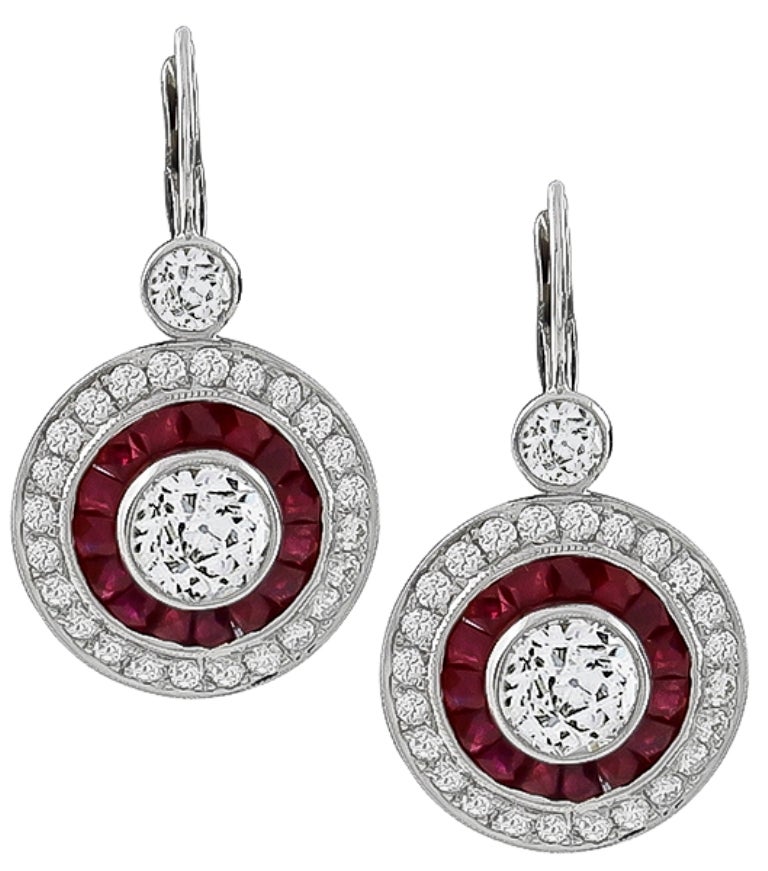 Made of 14K white gold, these earrings are centered with GIA certified old European cut diamonds that weigh 1.00ct and 1.12ct. and are graded J color with SI2 clarity. The center stones are accentuated by round cut diamonds weighing approximately