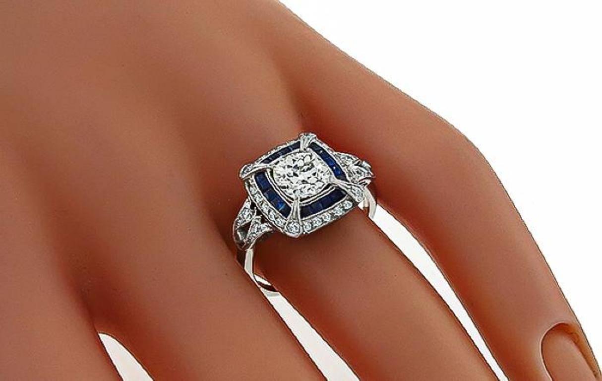 This stunning ring from the Art Deco era is centered with a sparkling cushion cut diamond that weighs 1.27ct. graded H-I color with SI2 clarity. The center stone is accentuated by high quality round cut diamonds and square cut sapphire accents.
The