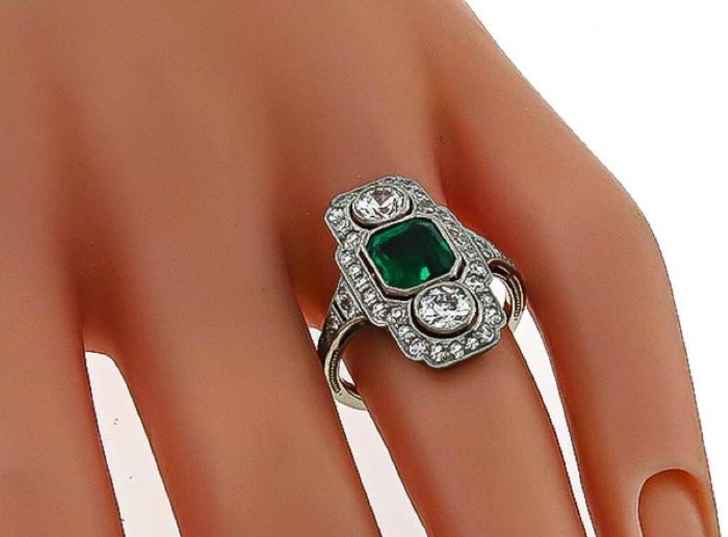 This stunning platinum ring from the Art Deco era centers a natural Colombian emerald that weighs approximately 1.75ct. The center stone is accentuated by sparkling old mine and round cut diamonds that weigh approximately 2.00ct. graded F-G color