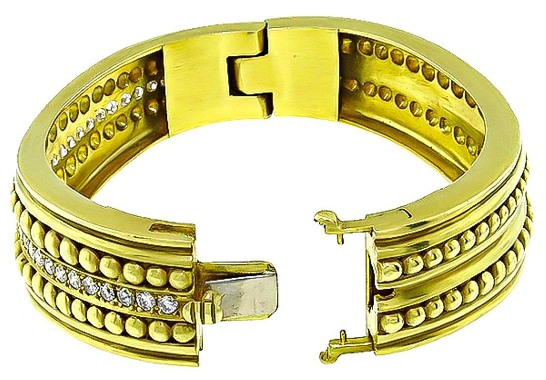 This fabulous 18k yellow gold bangle by Van Naltchayan is set with sparkling round cut diamonds weighing approximately 2.25ct. graded F color with VS1 clarity. The bangle measures 19mm in width at the widest base and will fit a standard wrist size.