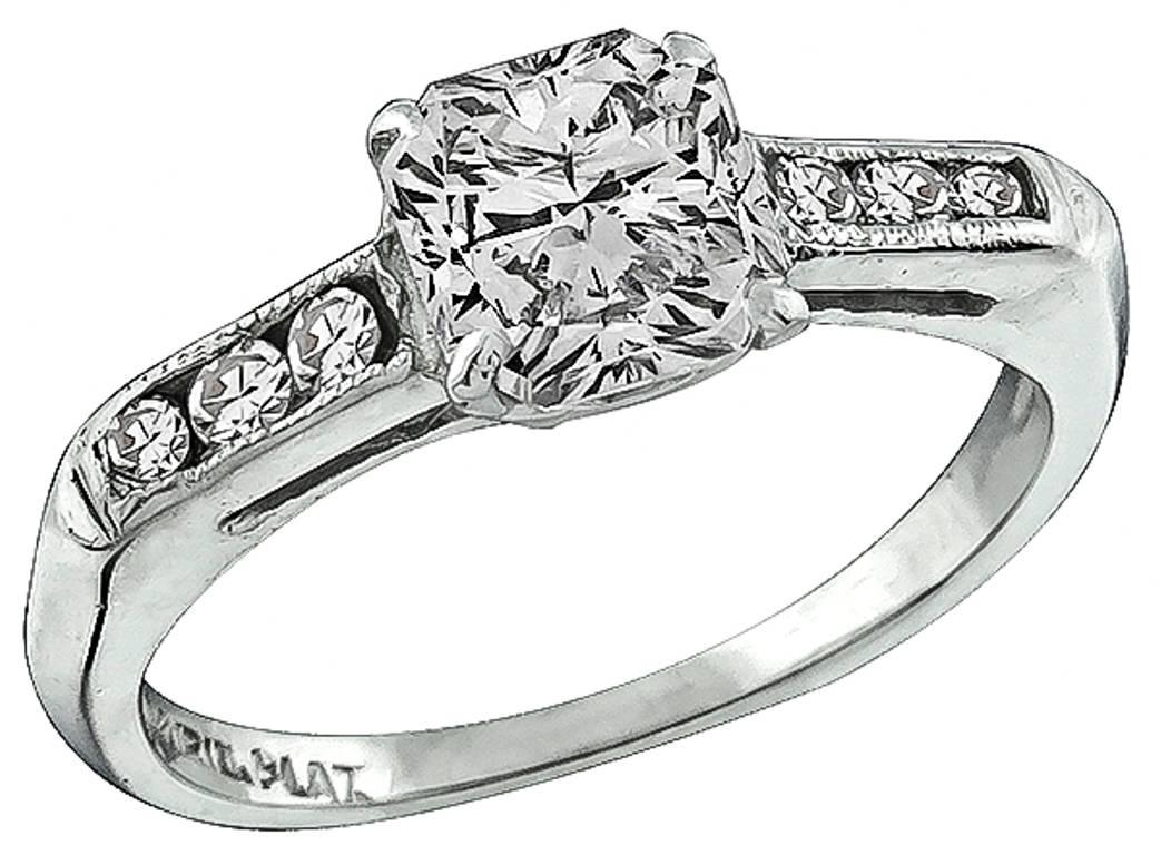 The ring centers a sparkling radiant cut diamond that weighs 1.02ct. and is graded H color with SI1 clarity. The center diamond and the wedding band are accentuated by round cut diamonds that weigh approximately 0.60ct. graded H color with VS