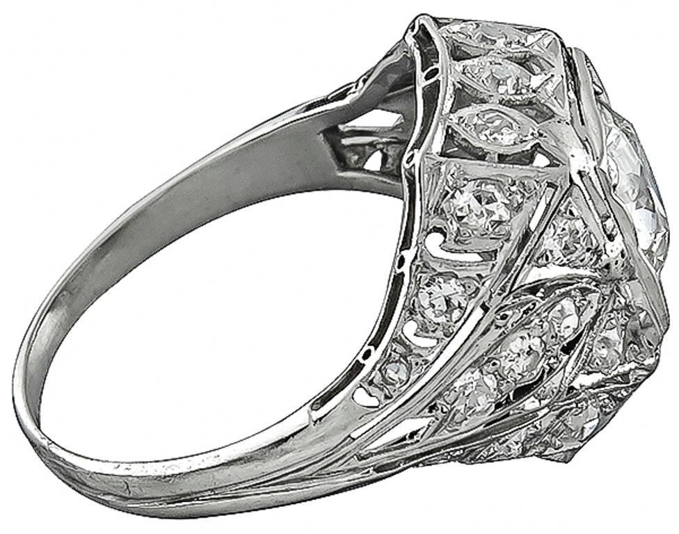 This stunning platinum ring from the Art Deco era is centered with a sparkling old mine cut diamond that weighs 1.25ct. and is graded I-J color with SI1 clarity. Accentuating the center stone are dazzling old mine cut diamonds weighing approximately