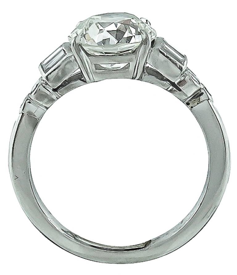 This gorgeous platinum engagement ring from the 1930s. is centered with a sparkling EGL certified old European cut diamond that weighs 2.35ct. and is graded I-J color with VS2 clarity. The center stone is accentuated by dazzling baguette and round
