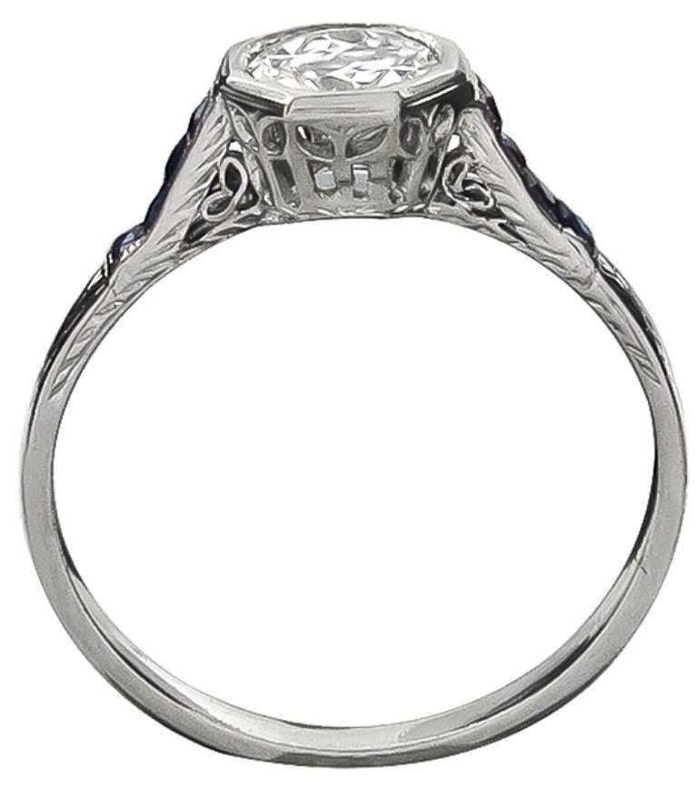 This elegant platinum ring centers a sparkling GIA certified round brilliant cut diamond that weighs 0.68ct. and is graded E color with VS1 clarity. The center stone is accentuated by vivid blue sapphire accents.
The ring is size 8 1/2, and can be