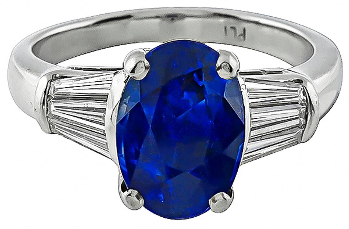 This amazing platinum ring is centered with a vivid blue oval cut sapphire that weighs 4.53ct. The center stone is flanked by sparkling baguette cut diamonds weighing approximately 0.50ct. graded F-G with VS1 clarity.
The ring is size 7 1/4, and