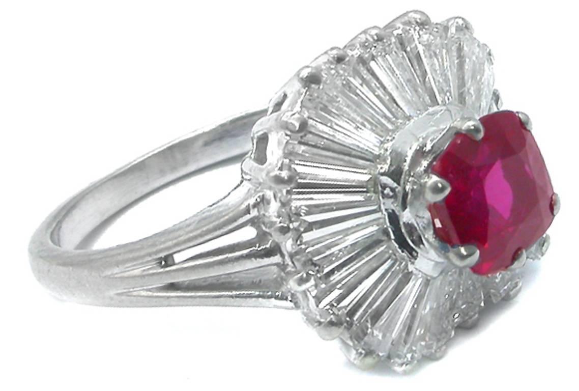 This enticing platinum ring from the 1960s centers a GIA certified cushion cut natural ruby that weighs 1.31ct with no indications of heating. Accentuating the ruby are sparkling tapered baguette cut diamonds weighing approximately 1.00ct. graded G