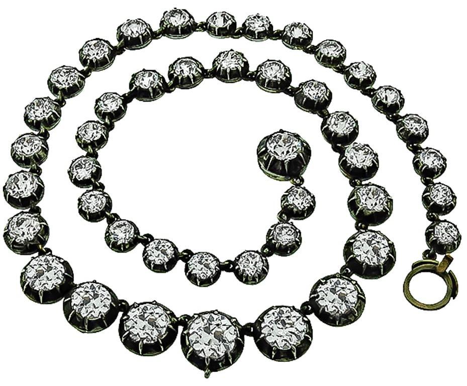 This stunning silver and gold necklace is set with 44 sparkling old mine cut diamonds weighing approximately 37.30ct. The color of the diamonds is J-K with VS clarity. The necklace has a tapering width from 7mm to 12mm towards the center and