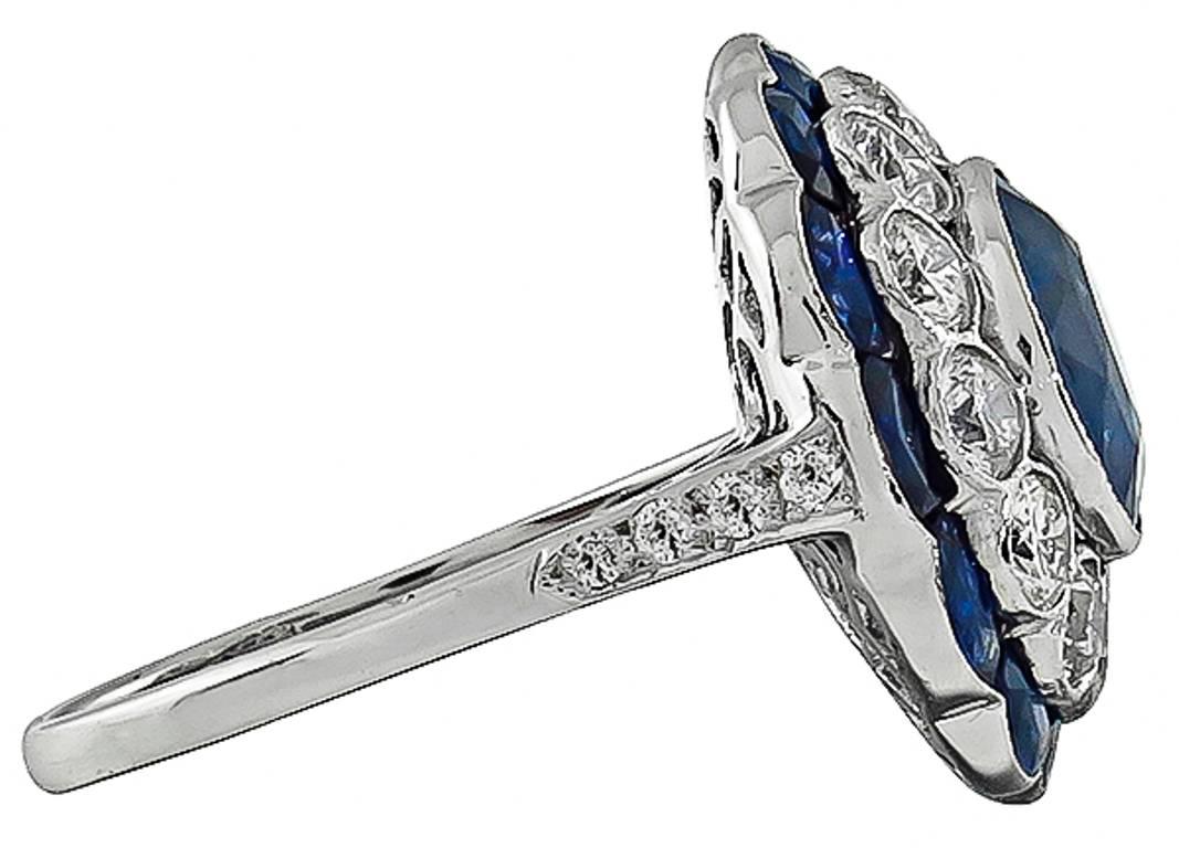 This 18K white gold ring is centered with a natural vivid blue Ceylon sapphire that weighs 3.54ct. The center stone is accentuated by sparkling round cut diamonds weighing approximately 1.30ct graded G color with VS and faceted cut sapphires that