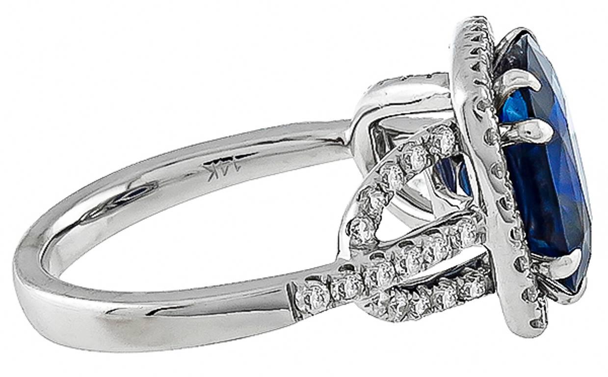 This amazing 14k white gold ring is centered with a gorgeous cushion cut sapphire that weighs 5.16ct. Accentuating the sapphire are sparkling round cut diamonds weighing approximately 1.00ct. graded H color with VS1 clarity. The top of the ring
