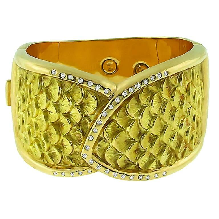 This amazing 18k yellow gold bangle bracelet features an elegant fish scale design set with sparkling round cut diamonds weighing approximately 1.10ct. graded G color with VS clarity.
The bracelet is stamped CIT ITALIAN 750 and will fit a standard