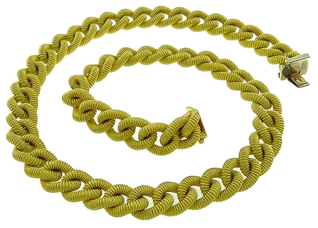 Made of 18k yellow gold, this necklace and bracelet set features an impressive geometric design motif. The necklace measures 16 inches in length and the bracelet measures  7 1/2 inches. The set is stamped Italy 18Kt 750 and weighs 64