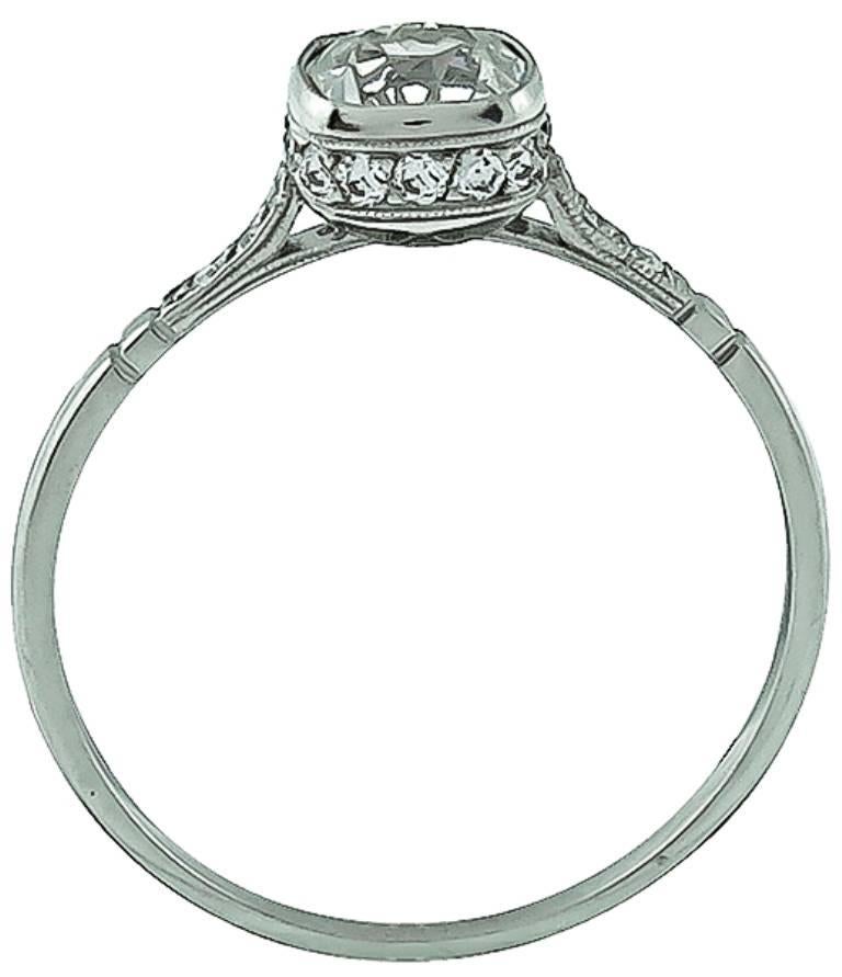 This elegant platinum ring is centered with a sparkling cushion cut diamond that weighs 0.78ct. graded J color with VS2 clarity. The center stone is accentuated by dazzling round cut diamond accents. 
The ring is size 7 1/2, and can be resized.