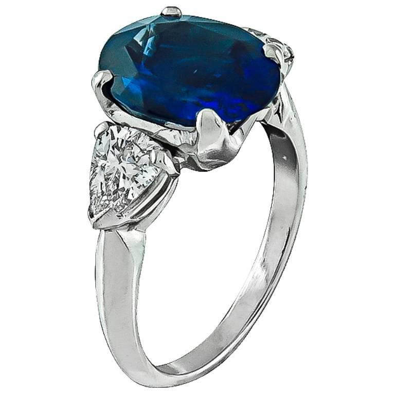 This amazing platinum engagement ring is centered with a vivid blue cushion cut Ceylon sapphire that weighs 3.72ct. The sapphire is flanked by sparkling pear shape diamonds weighing approximately 0.80ct. graded F color with VS1 clarity.  The ring is