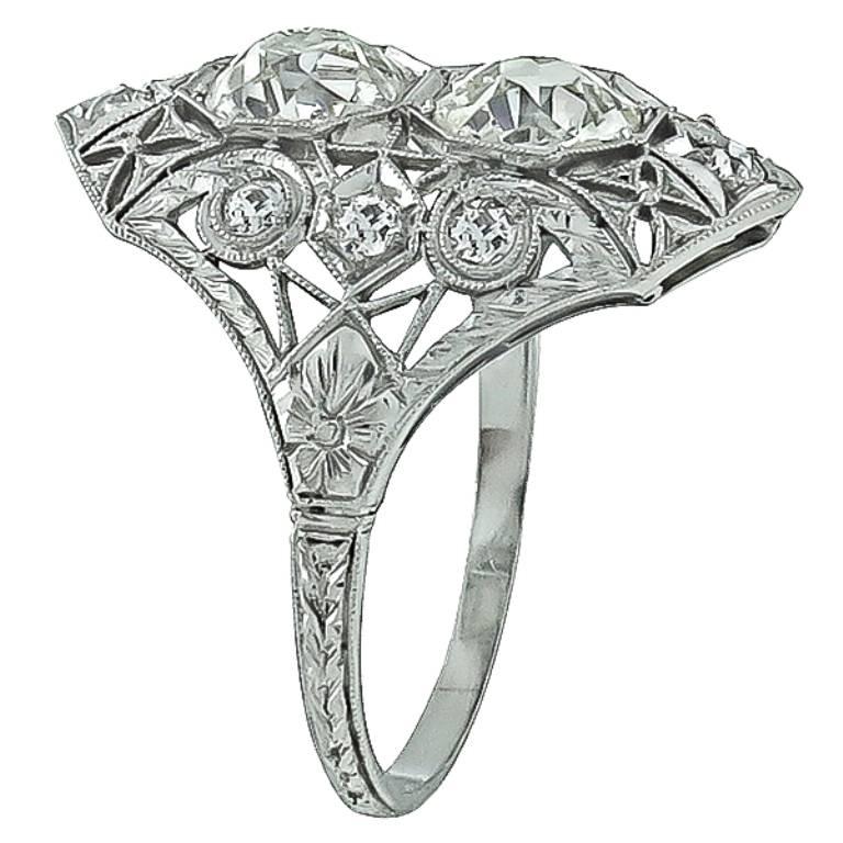 This stunning platinum ring from the Art Deco era, is centered with two sparkling old mine cut diamonds with an approximate total weight of 2.50ct. Accentuating the center stones are small old mine cut diamonds weighing approximately 0.30ct. The