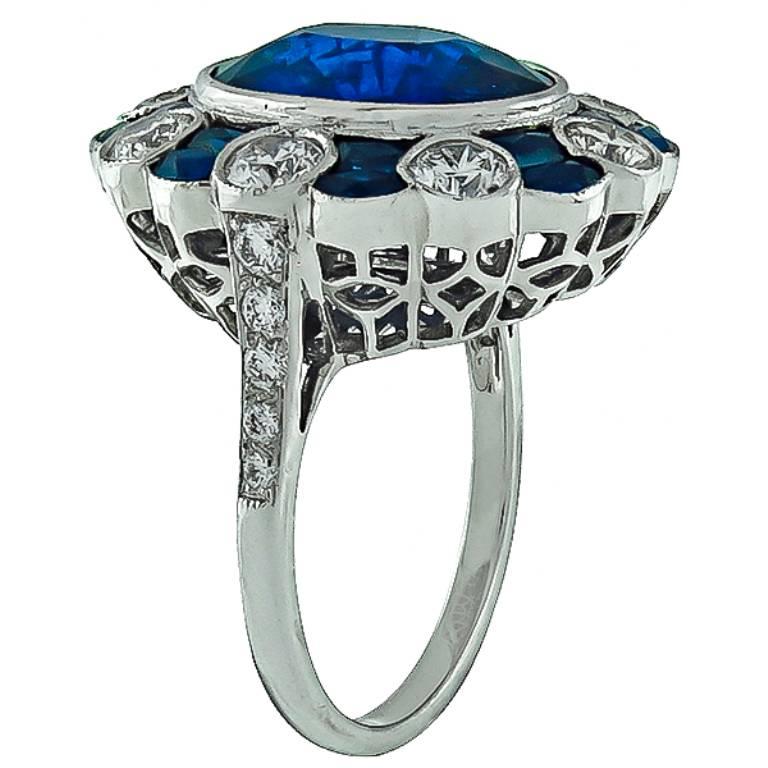 Made of 18k white gold, this ring is centered with a gorgeous oval cut sapphire that weighs approximately 6.00ct. Accentuating the center stone are faceted cut sapphire accents and sparkling round cut diamonds weighing approximately 1.00ct. graded