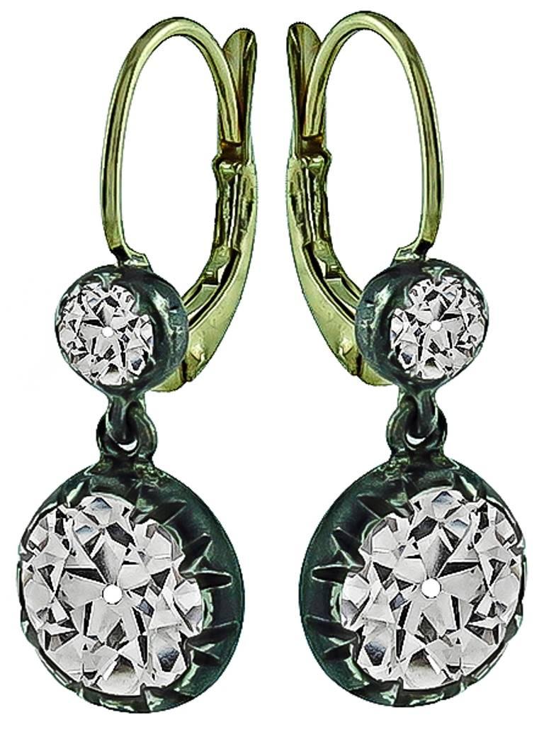 This stunning antique pair of silver and gold earrings from the Victorian era, feature sparkling old mine cut diamonds that weigh approximately 3.35ct. graded K color with VS clarity. The diamonds are accentuated by two small old mine cut diamonds